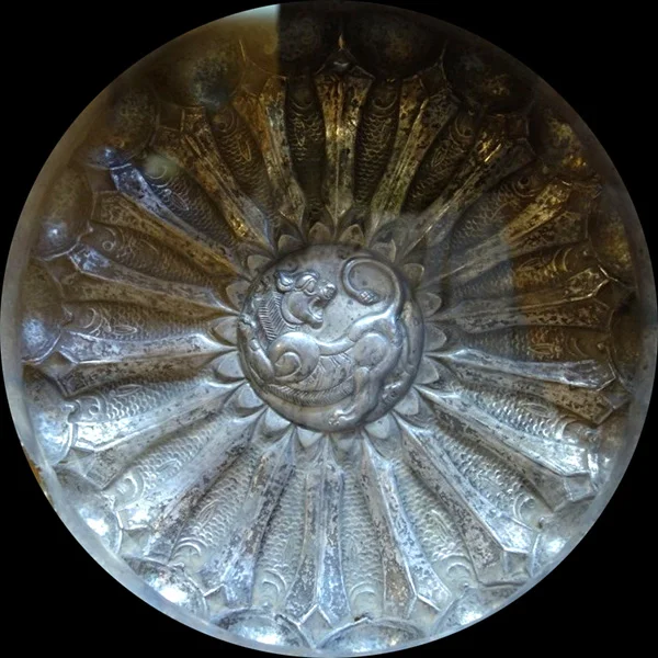 بشقاب هخامنشی. شیر در میانه می‌درخشد و ماهی‌ها در اطراف آن هستند. 